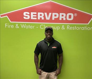 man standing in front of green wall with SERVPRO logo