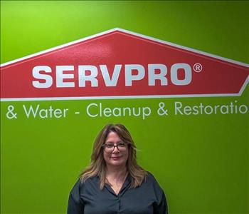 Woman standing in front of green and orange SERVPRO sign