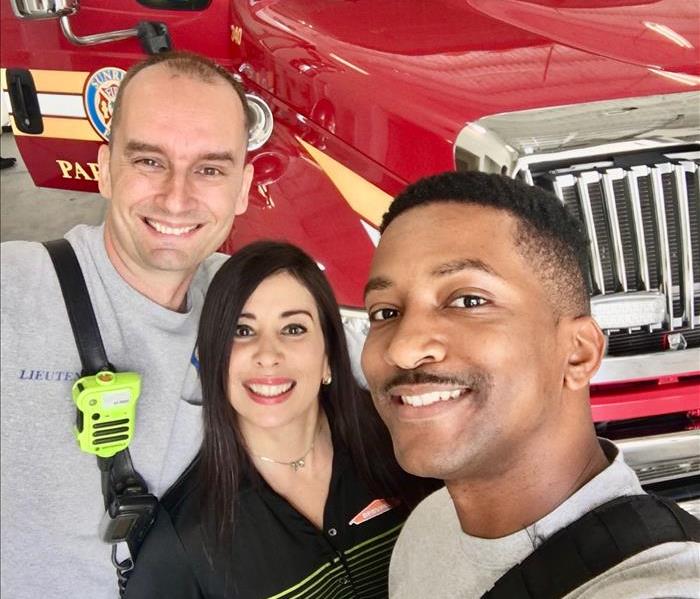 Three firefighters off duty posing with sales rep and a jar of candy